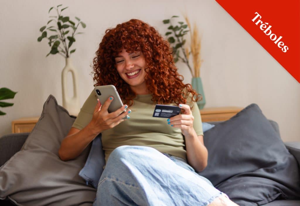 Mujer comprando online por su teléfono y ahorrando en Tréboles